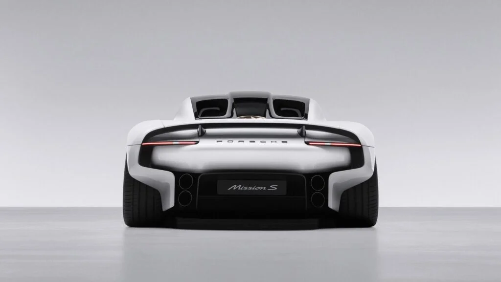 Rear view of the white Porsche Mission S concept in a pale grey studio, showing the full-width light bar, Porsche lettering and Mission S badge