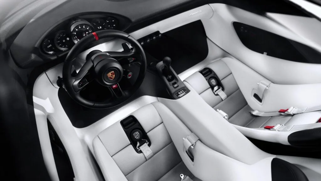 Overhead view of the Porsche Mission S interior in white and black, showing the steering wheel, round instruments, gearlever and seats
